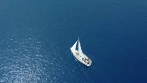 Sailboat in the middle of the blue ocean. A quick guide to sailing in North America