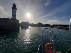 Entering a safe harbor. A light house with the sun in the background