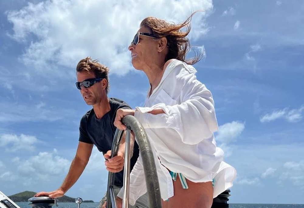 Sailing women and men enjoy boating and sailing together. Blue sky. The women is at the helm.