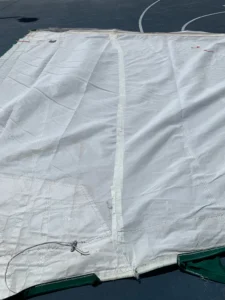 Temporary sail repair with a tape . sail is flat on the ground