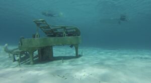sunken piano and two snorkeling divers