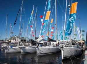 Sailboats aligned at the Annapolis Sailboat show with brands flags