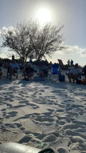 People sitting on their seat in the beach. Sun in the background