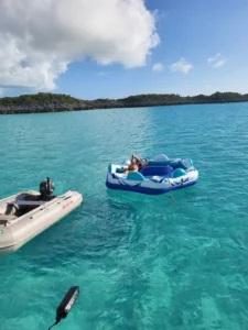 Dinghy and floating device on blue water is part of catamaran adventures in Exumas, Bahamas