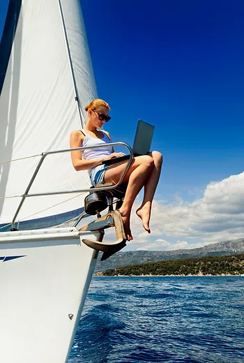 A female sailor is writing her sailing resume at he bow of a sailboat